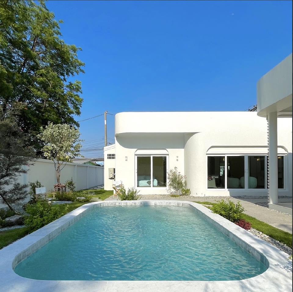 Villa A — สระว่ายน้ำขนาดใหญ่หน้าตัวบ้านปูนขาว