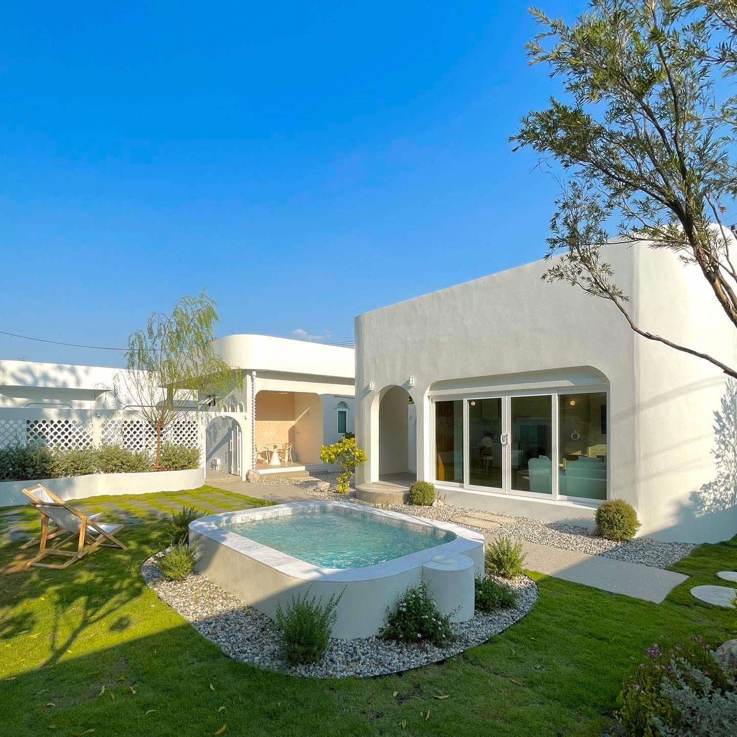 The Glam Pool Villa — ตัวบ้านปูนขาว ซุ้มโค้ง สระว่ายน้ำส่วนตัวและต้นมะกอกยามเย็น