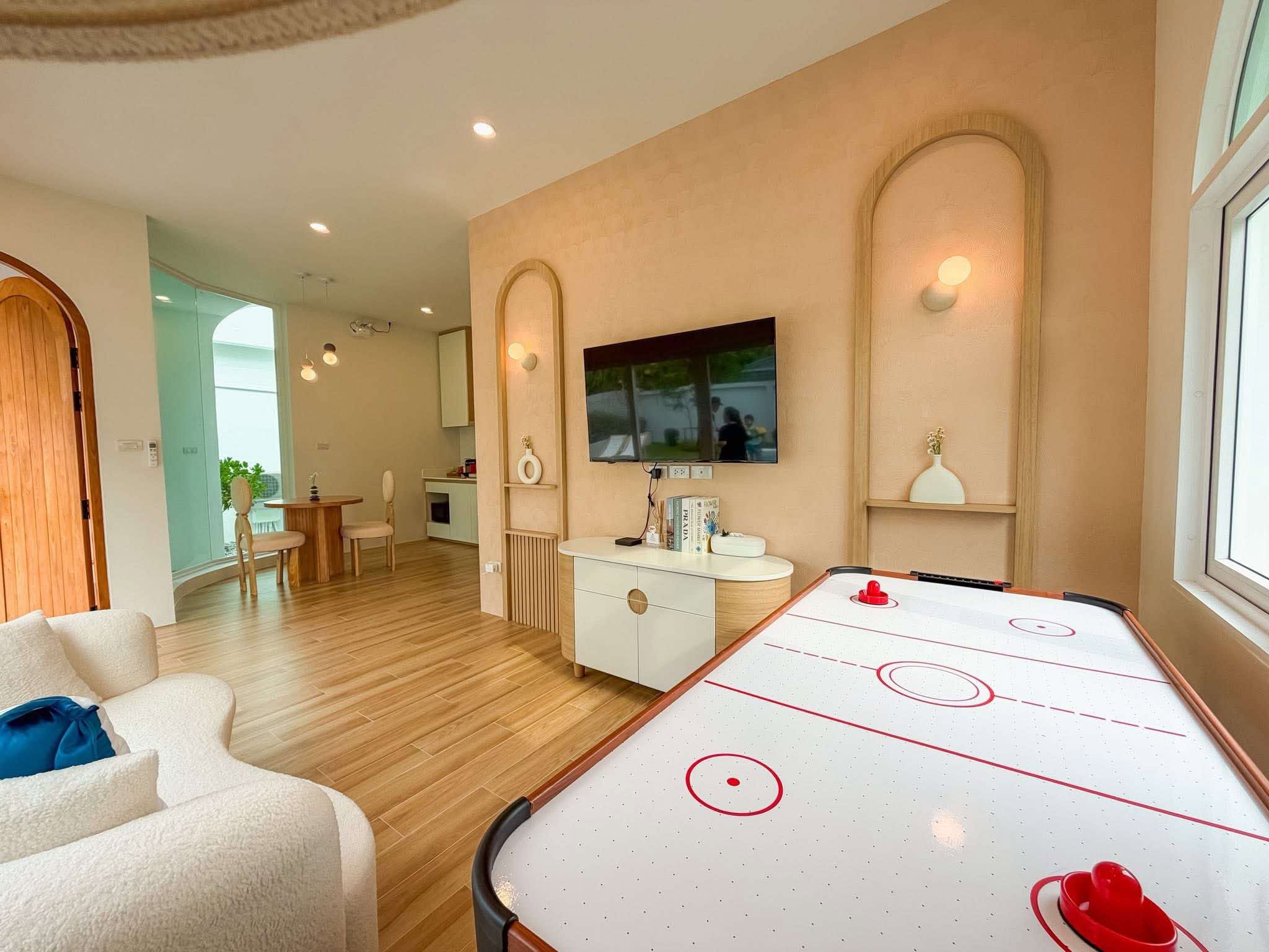 ห้องนั่งเล่น Villa B โต๊ะไอซ์ฮอกกี้ ซุ้มโค้ง และมุมมินิบาร์